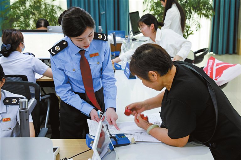图为税务工作人员指导群众办税
