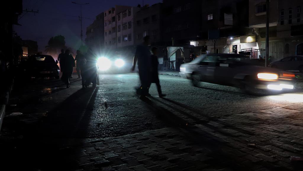 当地时间2023年10月16日，加沙地带的汗尤尼斯，人们走在黑暗的街上。