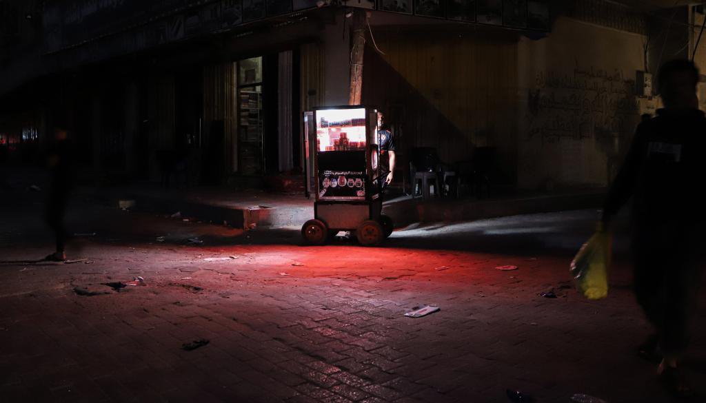 当地时间2023年10月16日，加沙地带的汗尤尼斯，黑暗中的小商贩。