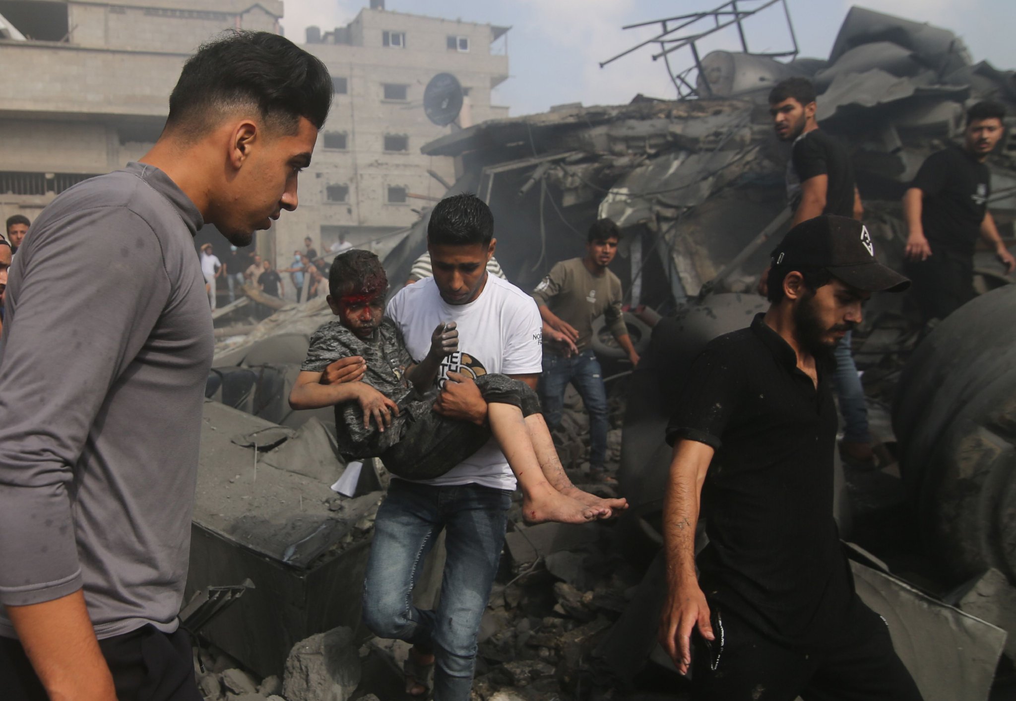 ▲10月22日，在加沙地帶南部城市拉法，人們在遭以色列襲擊損毀的建築廢墟上救援。圖/新華社
