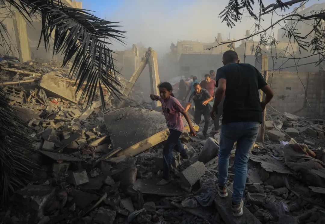 11月6日，人們從加沙地帶中部地區一處被炸難民營逃離。新華社發（亞西爾·庫迪攝）