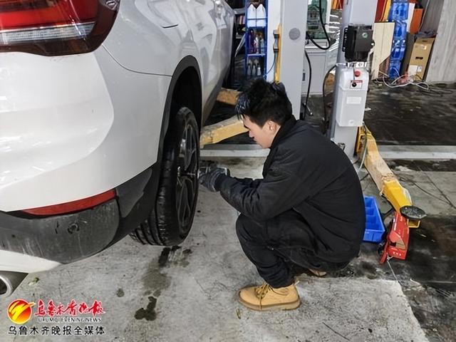11月14日,汽修店的工作人员正在为车辆更换雪地胎。记者王璇摄