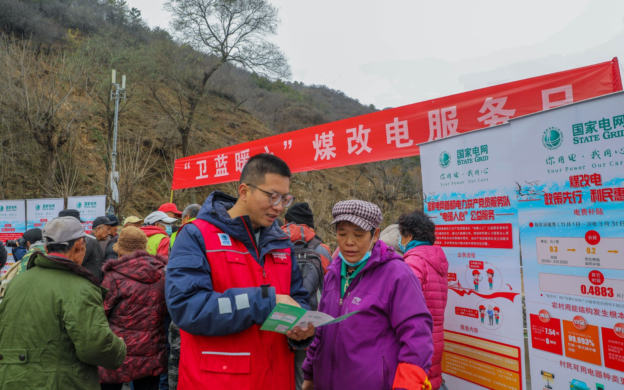 11月15日，國網北京電力妙峰山供電所駐村經理張立誌在炭廠村為村民講解「煤改清潔能源」便民服務舉措。張文靜 攝