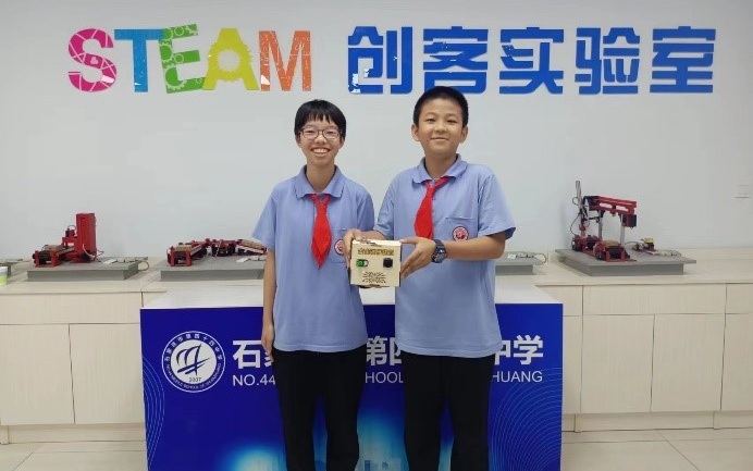 石家莊第四十四中學的初一學生楊白冰、郭夢瑤,以及他們花了三個月時間製作「安全暖行裝置」。受訪者供圖