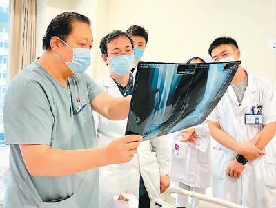 图为武勇(左一)在为患者进行诊断。北京积水潭医院供图