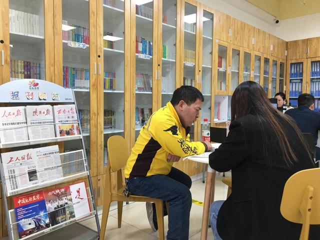 外卖小哥穆涛在莲心港湾阅读报纸。梁楚淇 摄
