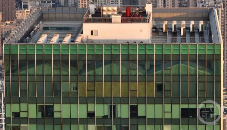 从写字楼玻璃外墙看去，只能看到房屋屋顶轮廓。摄影/上游新闻记者 沈度