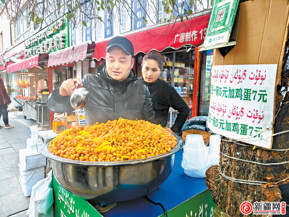 图为美食店店员正在烹饪鹰嘴豆等待食客光临。(全媒体记者马婷摄)