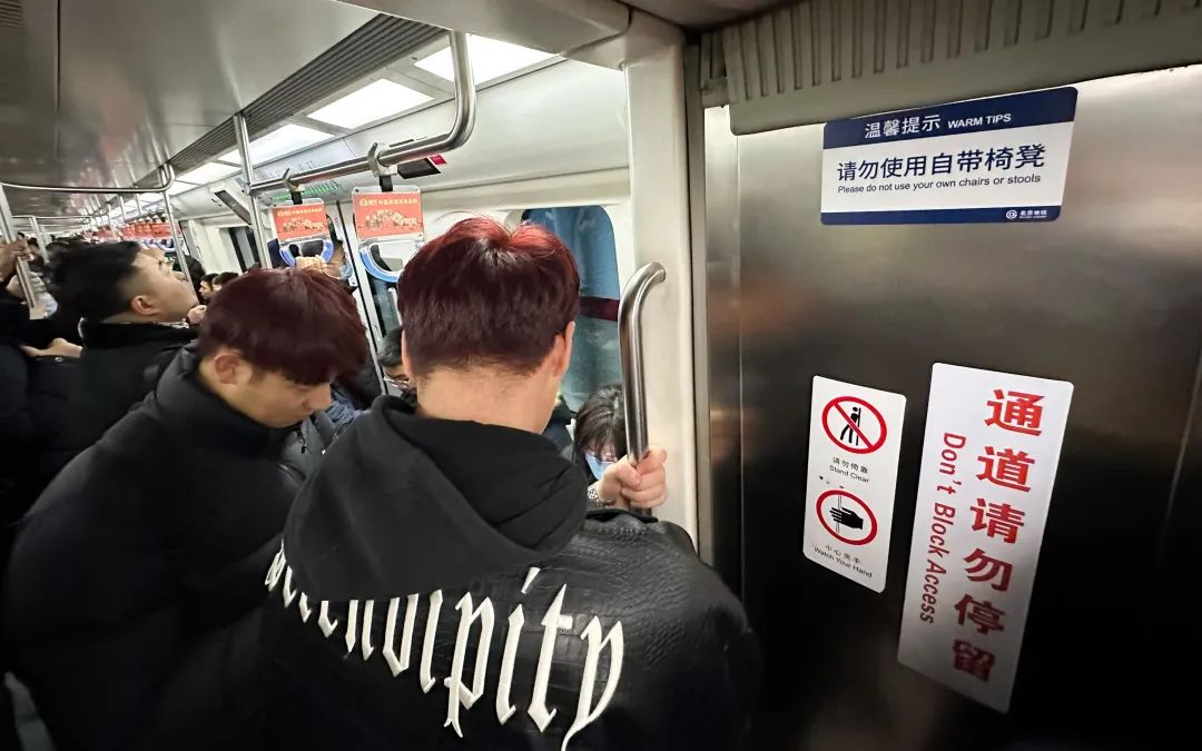 ▲地铁10号线,在车厢间连接处贴有“通道请勿停留”标识。新京报记者 裴剑飞 摄