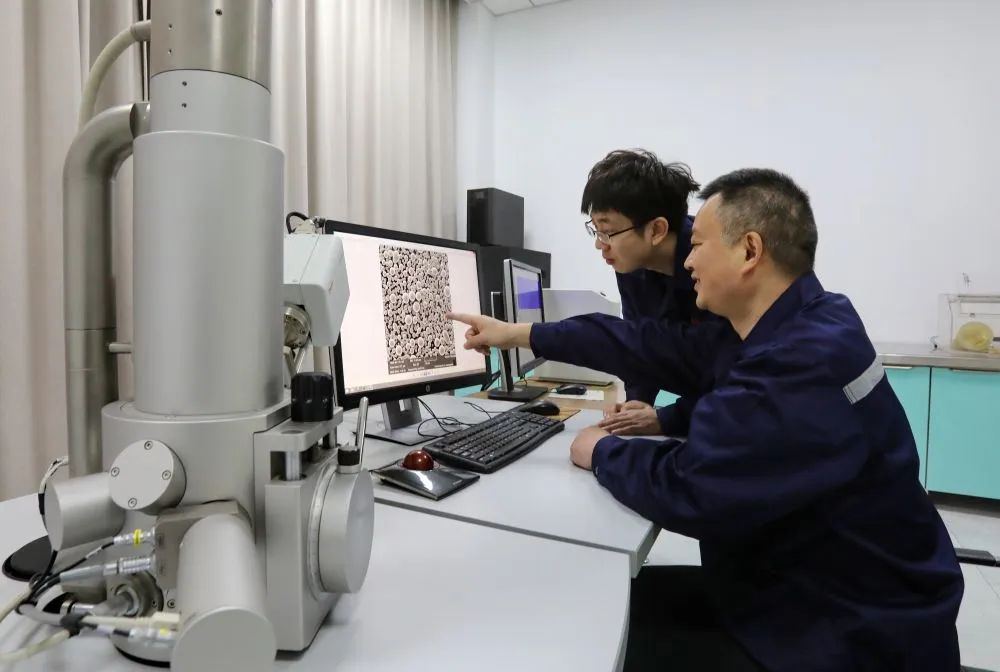 12月14日,邱田(右一)和团队同事在实验室工作。(受访单位供图)