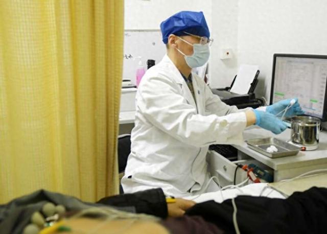 复旦肿瘤医院医生用加热的无菌棉球擦拭心电图贴片。复旦肿瘤医院供图