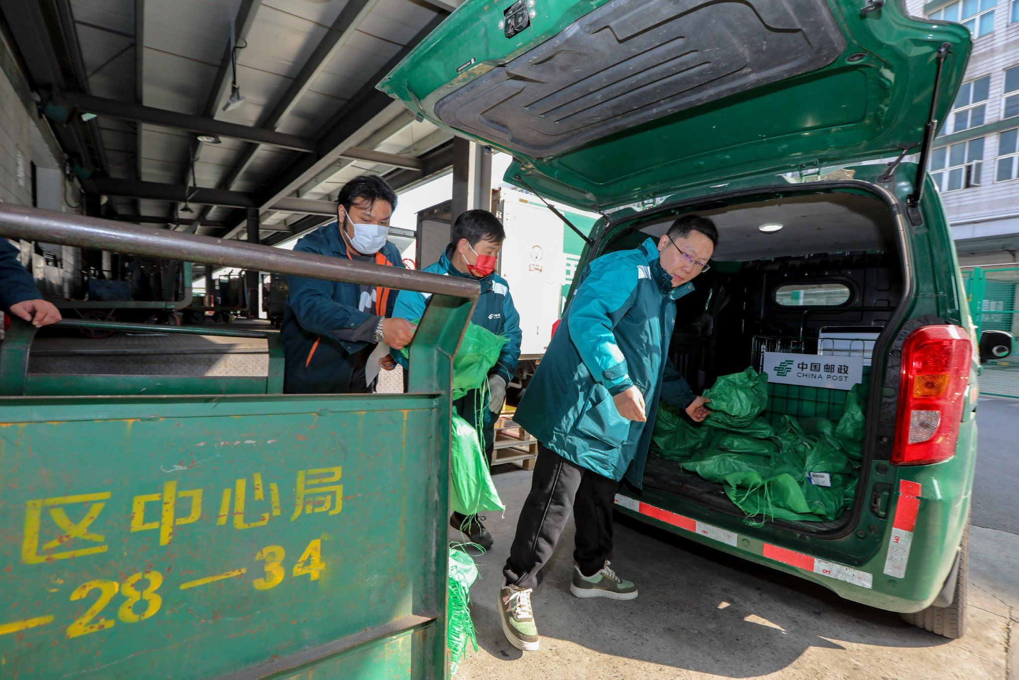 在位于沪太路的报刊处理场地，邮政工作人员将试点地铁运快递业务的报刊杂志用统一邮袋封装后，运输至延长路地铁站。