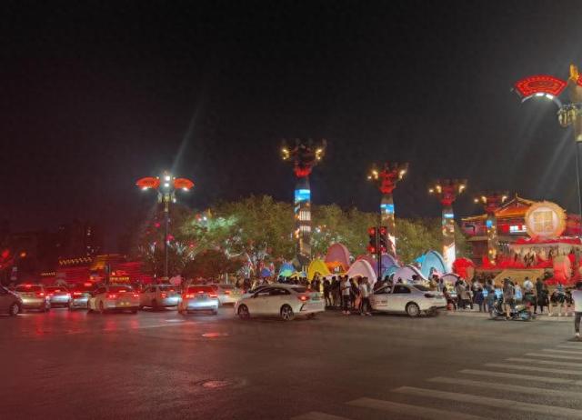 大唐不夜城开元广场路边停靠着许多揽客的小轿车。人民网陕西频道调查组拍摄