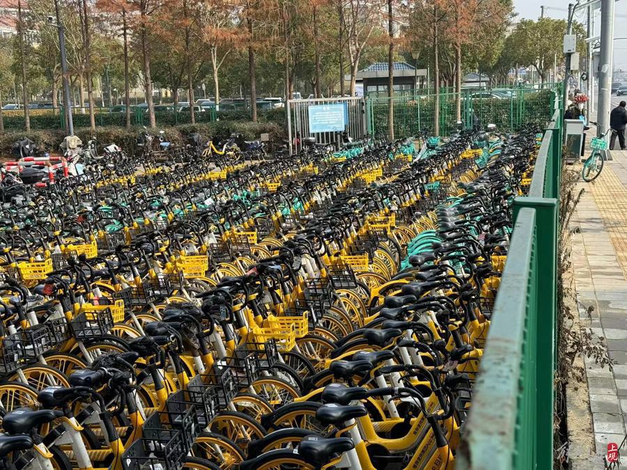 成百上千共享单车、电动自行车停放在2号口外。