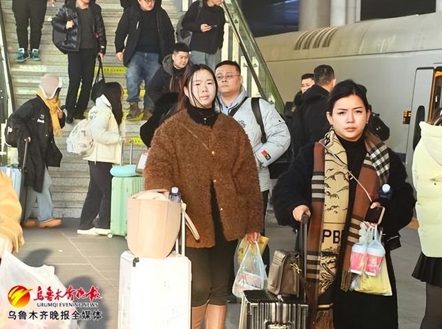 1月10日,在乌鲁木齐站站台,乘坐乌鲁木齐至兰州西D2706次列车的乘客准备乘车出行。记者陈岩摄