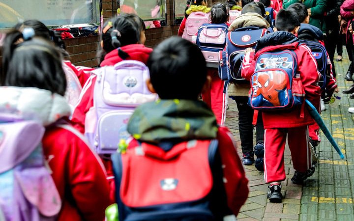 ▲資料圖：小學生背著書包走在放學路上。圖/新華社