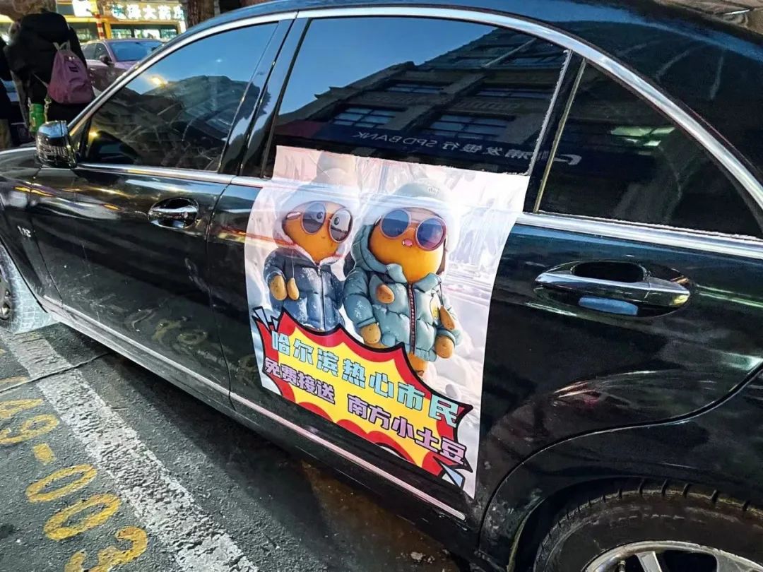 哈尔滨街头停放的私家车上,贴着免费接送南方“小 土豆”的海报。摄影/李莹