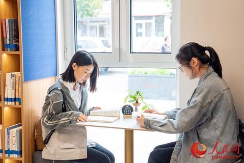 书吧里,两位年轻的居民在享受安静的阅读时光。人民网记者 孙翼飞摄