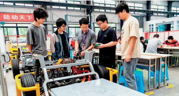 学院双岗教师带领学生在自研新能源汽车综合实训台上开展实训课程