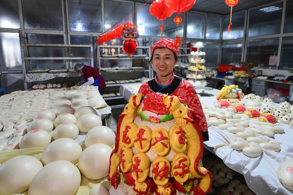 2月1日,在青岛市城阳区红岛街道一家花馍店,工人在展示龙年大吉花饽饽。王海滨 摄