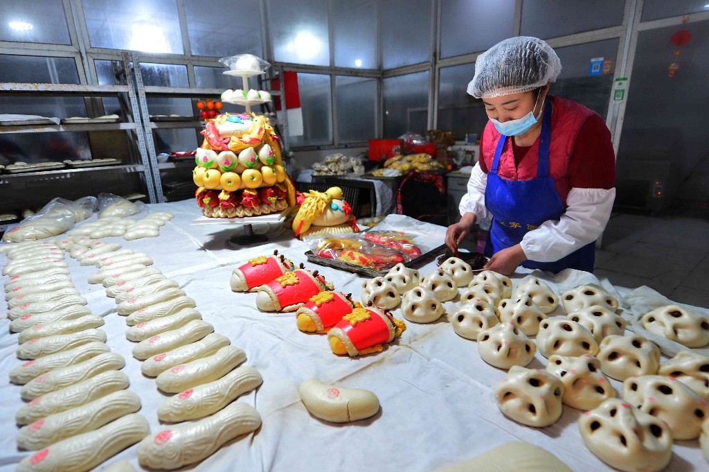 2月1日,在青岛市城阳区红岛街道一家花馍店,工人在摆放各式花馍。王海滨 摄