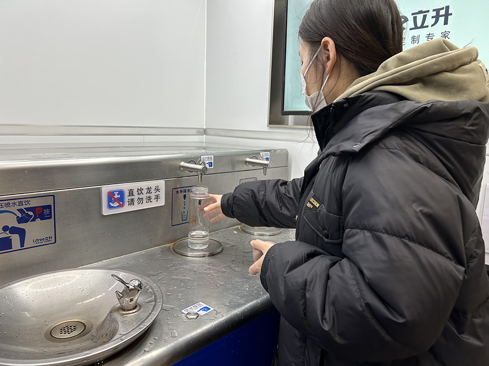 2月4日凌晨,上海虹桥火车站候车大厅,候车旅客在使用饮水机接热水。