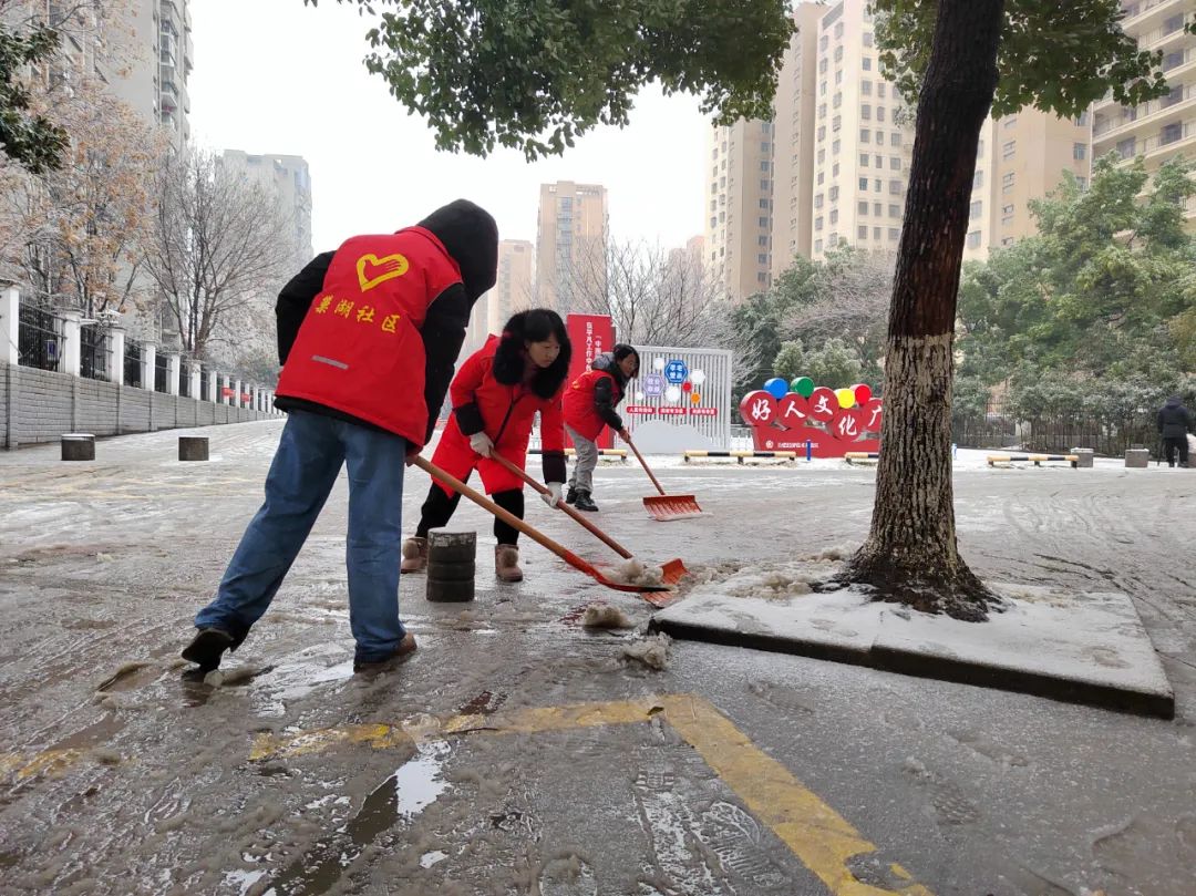 新港工业园志愿者对部分积雪区域进行清扫。