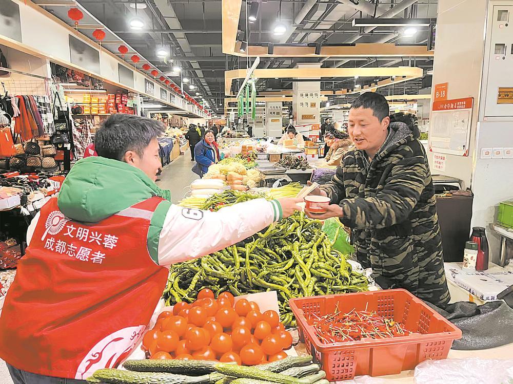 志愿者将煮好的饺子送到菜市商家手中