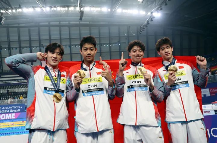 2月11日，中国队选手王浩宇、张展硕、季新杰和潘展乐（从左到右）在颁奖仪式后合影庆祝。新华社记者 雒圆 摄