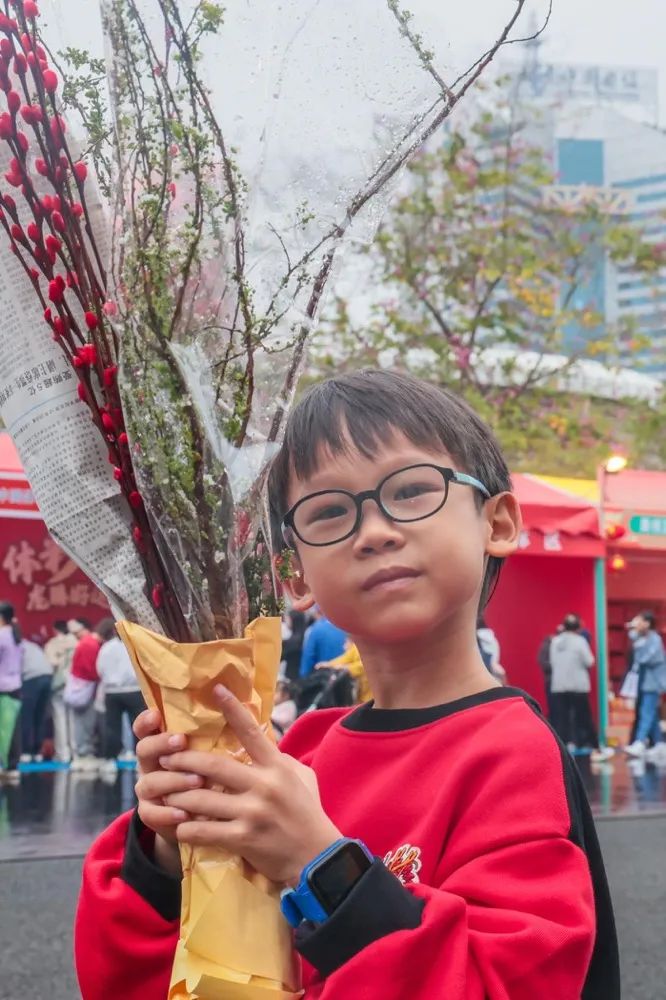 天河迎春花市,小男孩展示自己刚买的花卉
