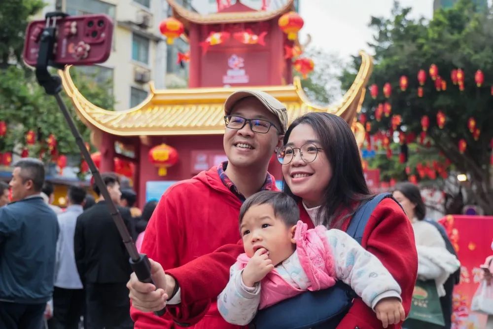 越秀西湖花市,一家三口“行花街”在龙门前合照