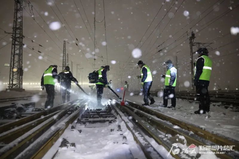 新疆铁路部门工作人员在连夜清除线路上的积雪。赵博川摄