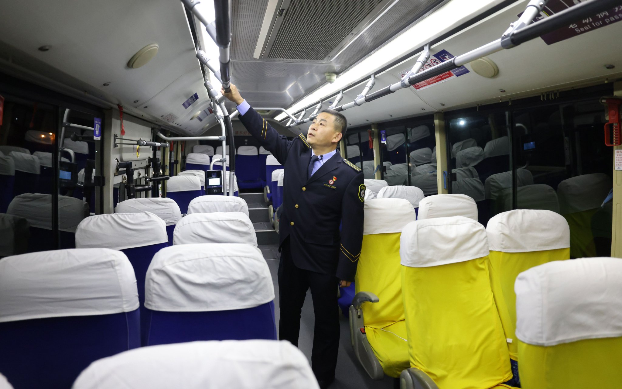 2024年1月29日清晨，李建龍在發車前對公交車內的扶手、座椅等進行檢查。新京報記者 王貴彬 攝