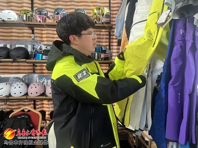 在白云滑雪场新开的高端单板雪具租赁店内,店铺负责人谭可正在整理滑雪服。记者王煜摄