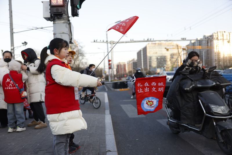 寒假期間，小誌願者在交通路口進行交通安全誌願服務。新京報記者王遠征 攝