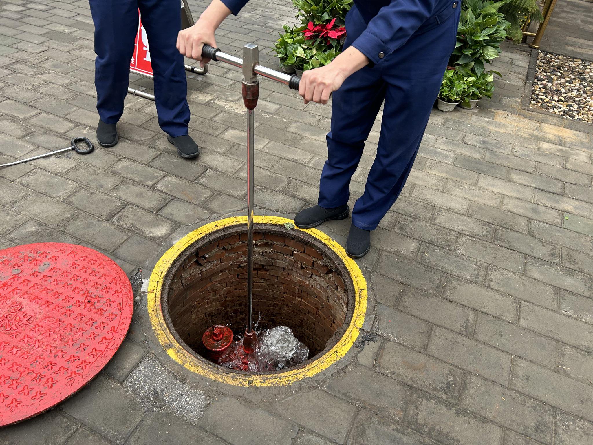 消防救援人員對地下消火栓出水情況進行測試。 新京報記者 彭鏡陶 攝