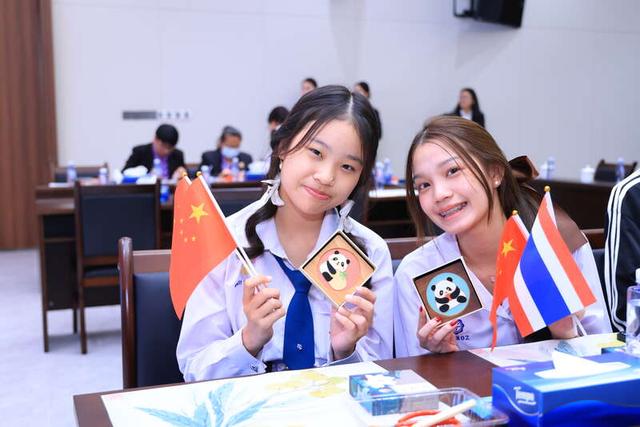 4月2日,北京,泰国教育工作者访问团和玫瑰园中学孔子课堂夏令营团学生代表展示自创掐丝珐琅作品。主办方供图