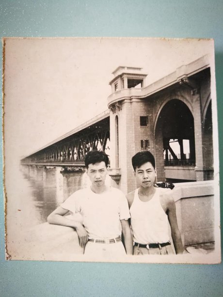     張勇傳和兄長在長江大橋下合照留念。受訪者供圖