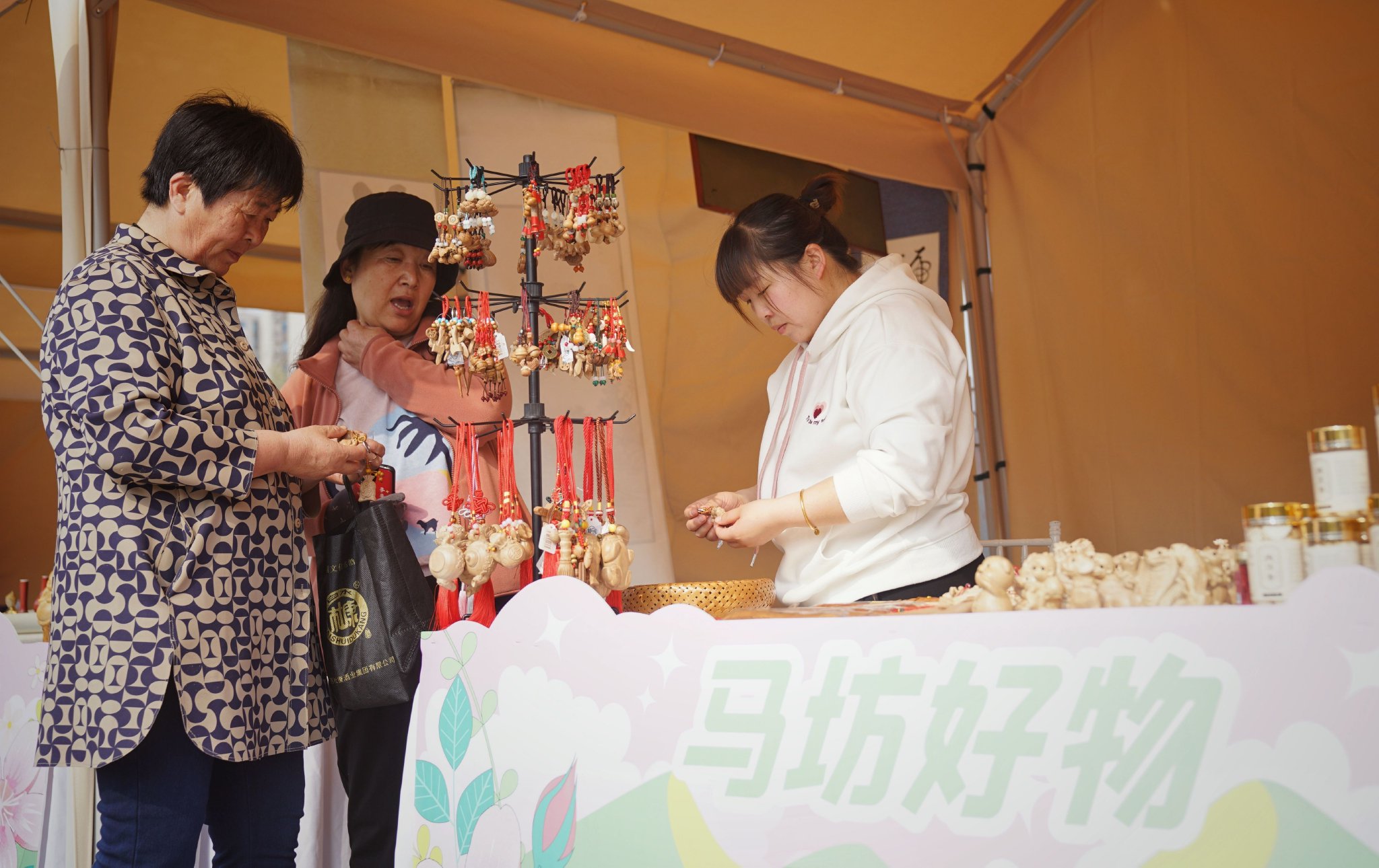 兩位顧客在文創市集挑選桃木製品。新京報記者 薛珺 攝