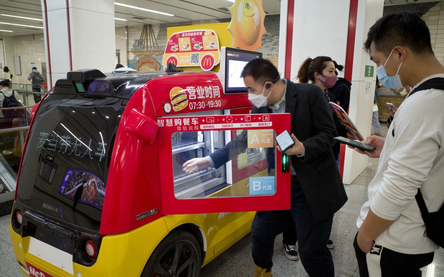 2023年3月29日，北京地鐵6號線朝陽門站，一名乘客正從無人餐車中取出早餐。新京報記者 王貴彬 攝