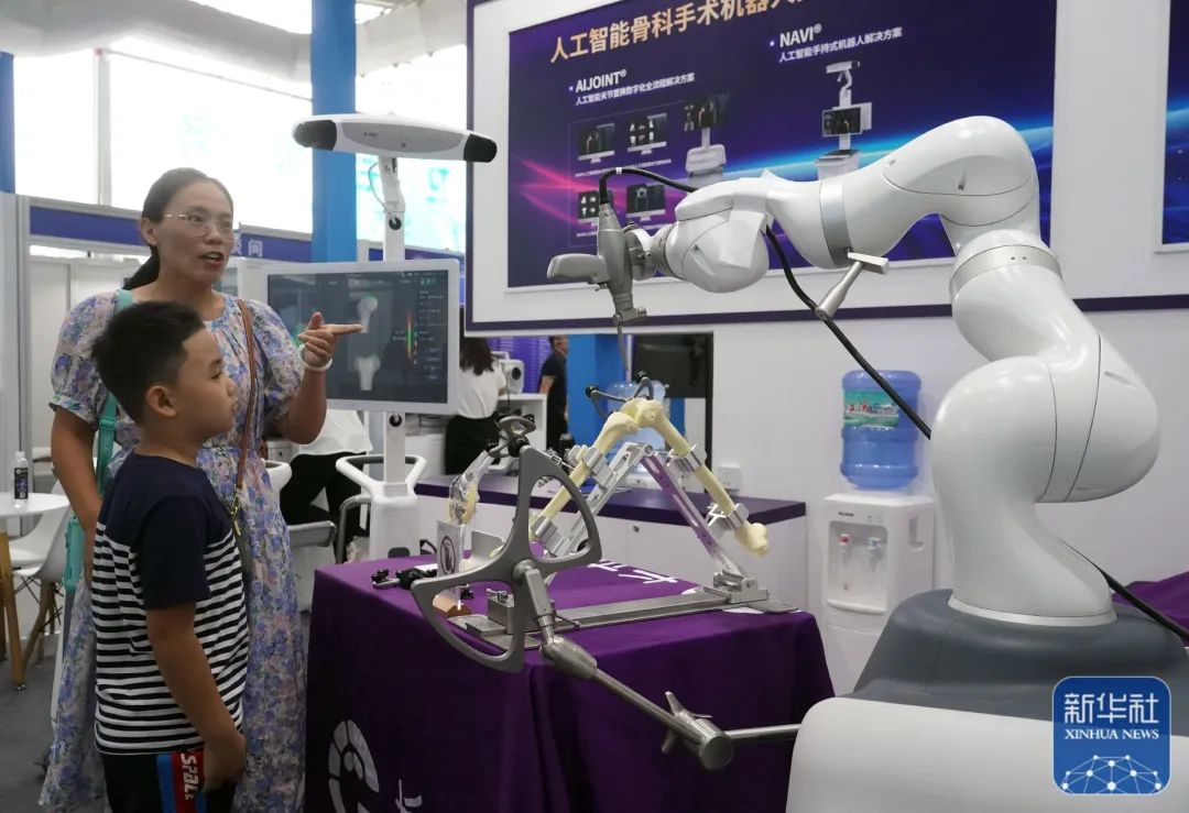 學生在參觀瞭解人工智能骨科手術機器人。圖片來源：新華社（記者：任超）