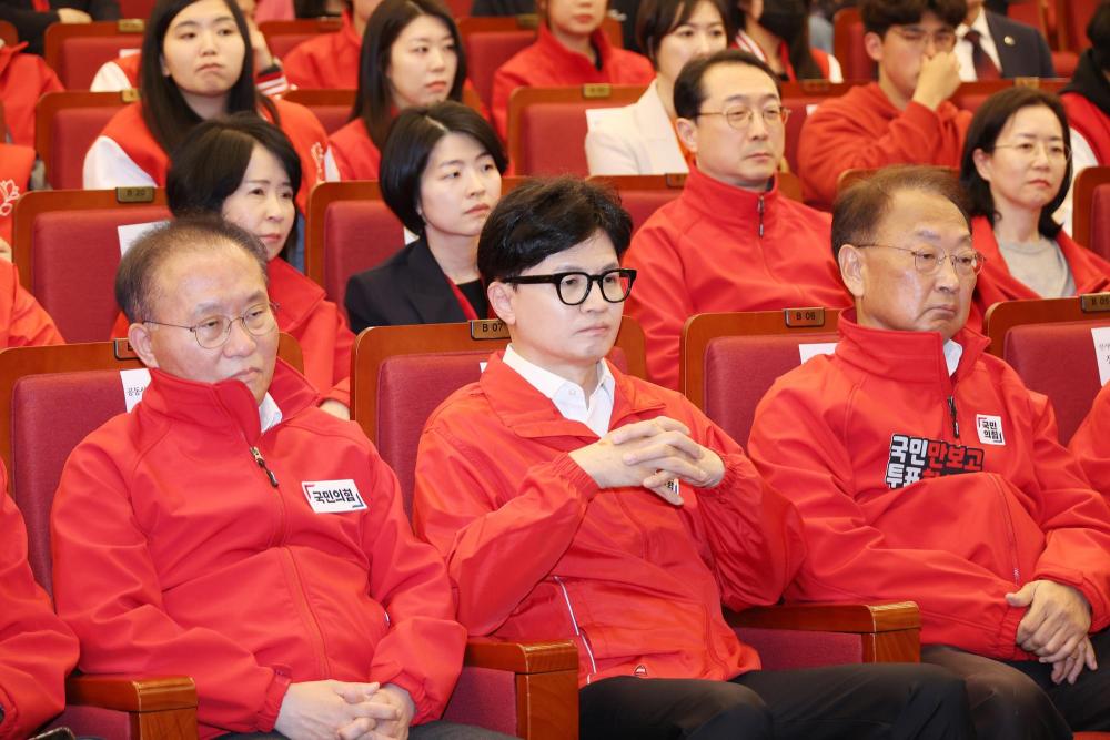 4月10日，在南韓首爾，國民力量黨領導人韓東勳（前排中）觀看出口民調。新華社/紐西史東斯訊社