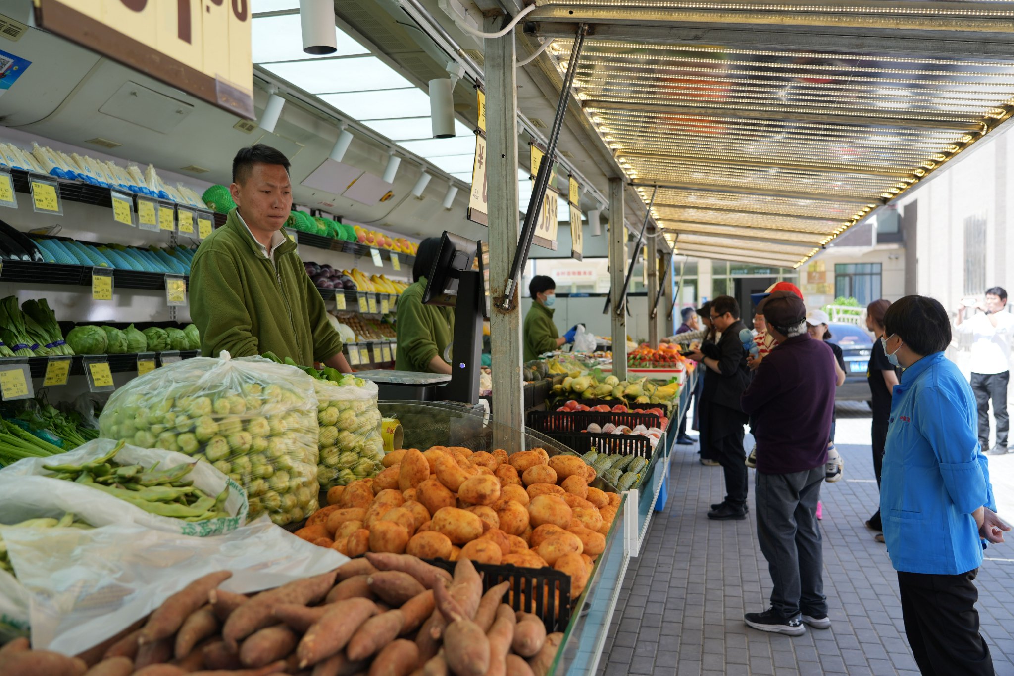 貨架上擺放著各種新鮮果蔬，市民正在井然有序地選購。新京報記者 陶冉 攝