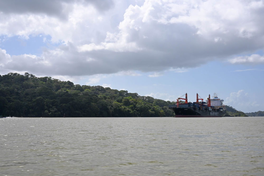 在巴拿馬首都巴拿馬城附近，一艘集裝箱船駛過巴拿馬運河中段的加通湖（2023年12月7日攝）。新華社記者陳昊佺攝