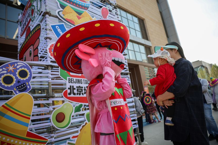 塔可節吉祥物玩偶「蠑墨墨」與遊客互動。新京報記者 王子誠 攝