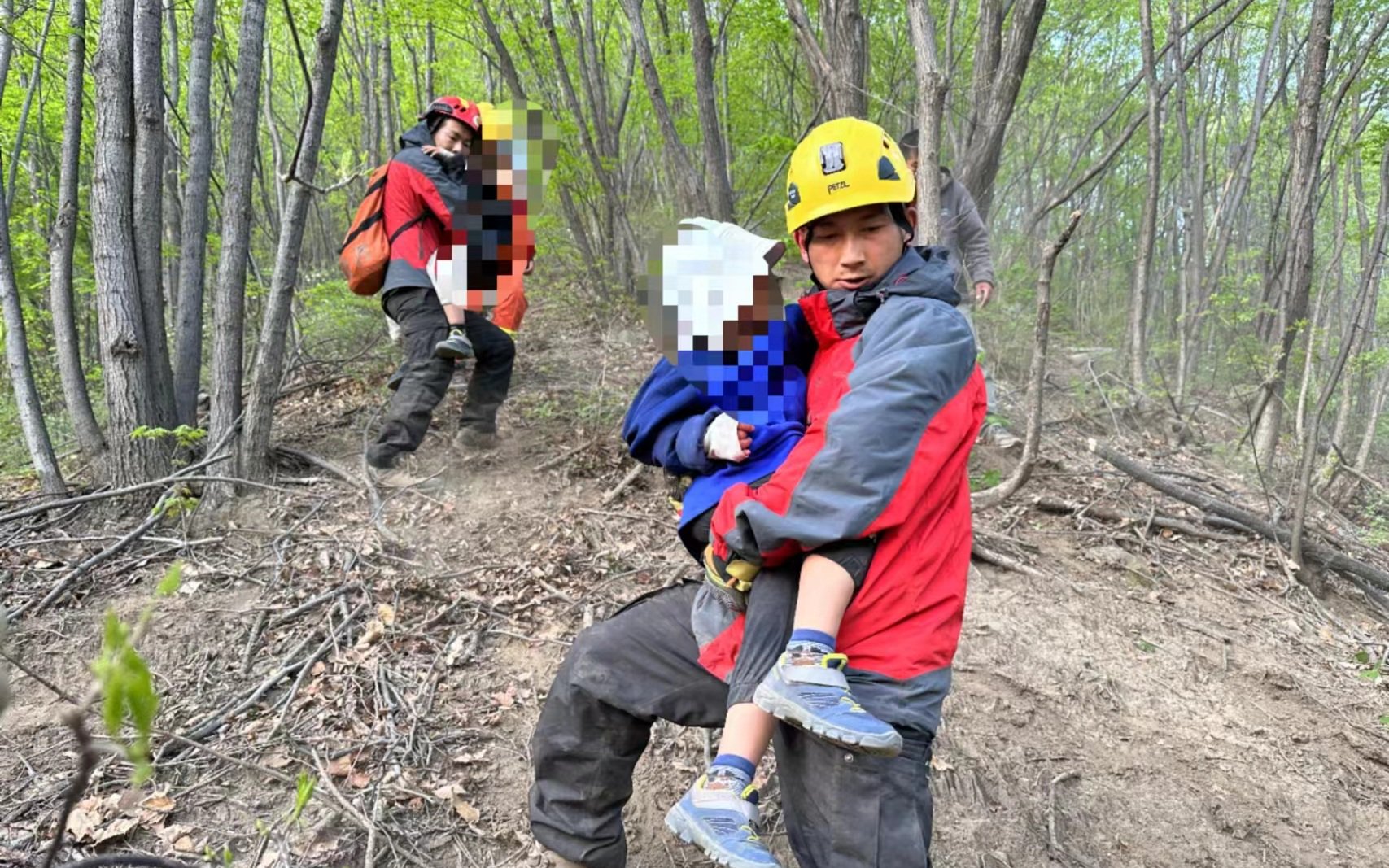 消防救援人員抱著孩子往山下走。圖源：懷柔區消防救援支隊