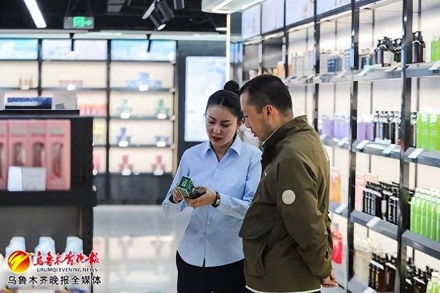 4月22日,在美林购跨境保税购物体验中心,工作人员在给顾客介绍商品。记者米热扎提·木塔力甫摄