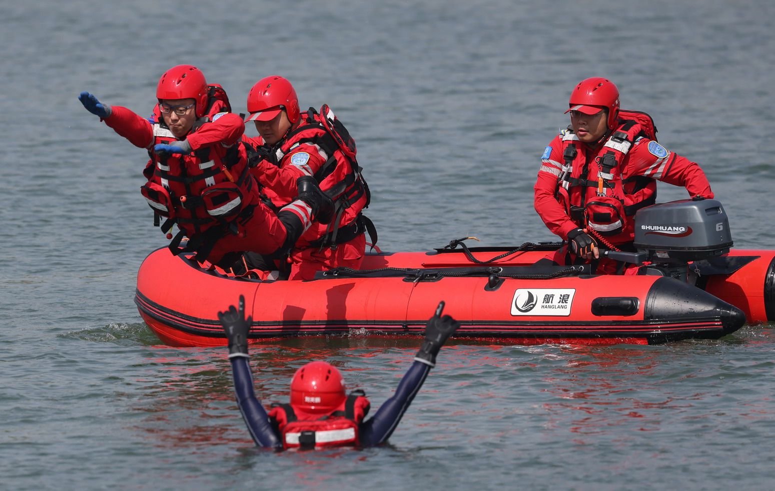 「衝鋒舟活餌救援」項目演練中，救援隊員奮力跳入水中，幫助落水者脫離危險區域。新京報記者 李木易 攝