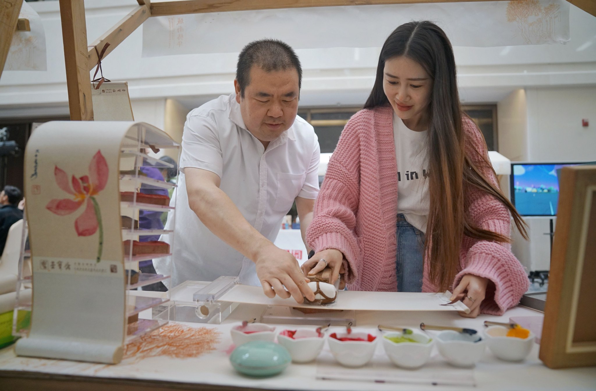 4月29日，西城區椿樹街道文化建設三年行動計劃發佈儀式上，一位女士體驗木版水印技藝。新京報記者 薛珺 攝