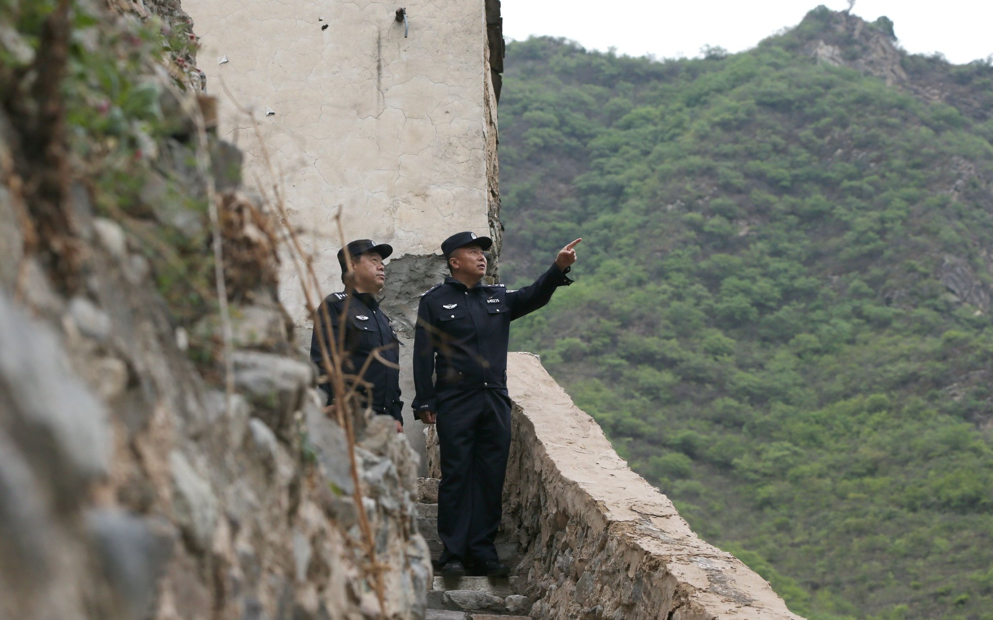 李英海（右）在這裏進出往返已有15個春秋，沿線的村莊、道路、山林，他都再熟悉不過。 圖源：北京市公安局